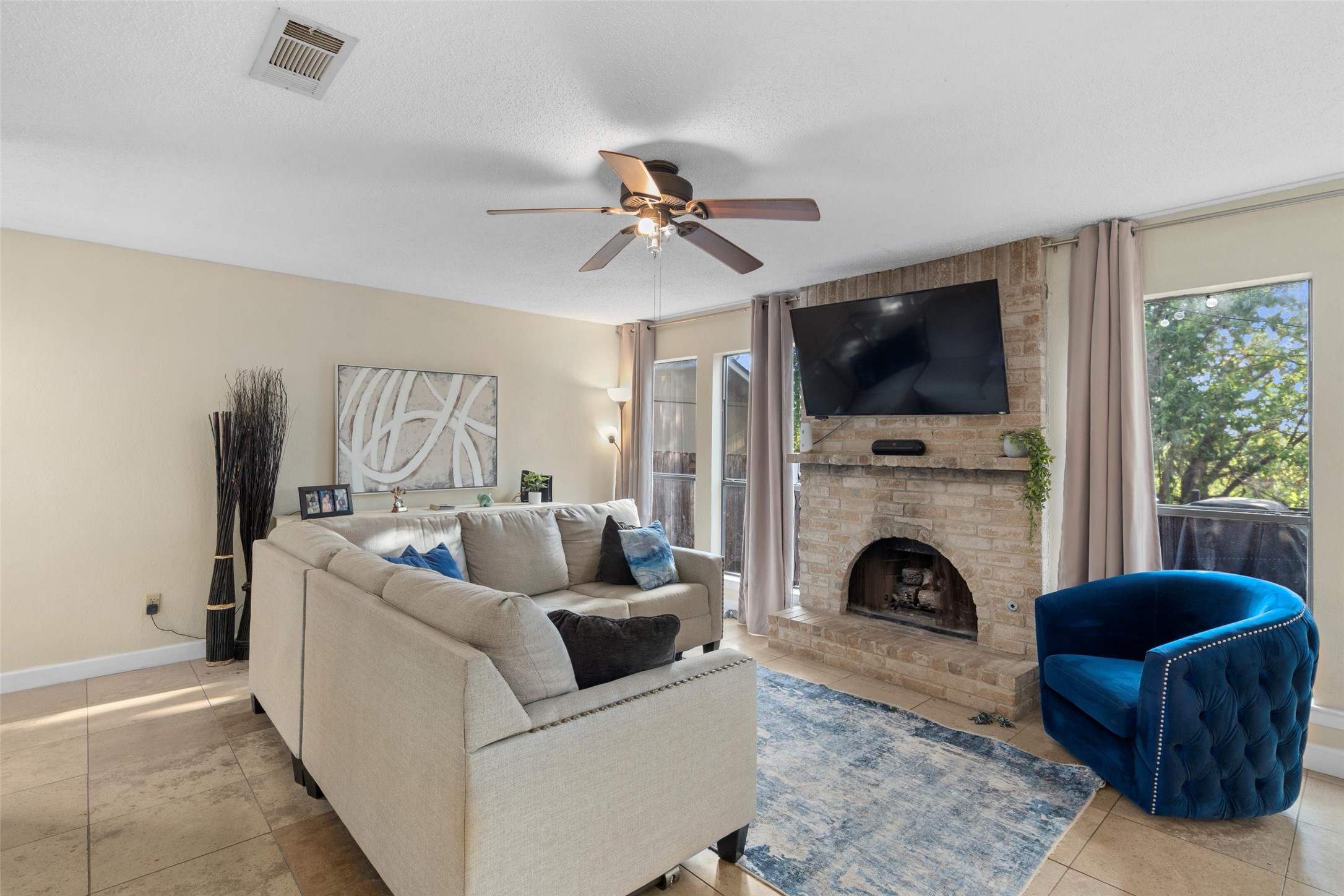6492 Hart Lane Austin, TX 78731 - Photo 4 of 22 Living area with plenty of natural light, ceiling fan, light tile patterned floors, and a fireplace