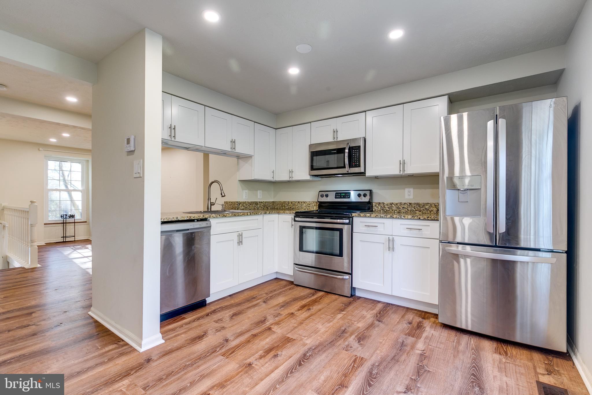 1589 Woodcrest Drive Reston, VA 20194 - Photo 12 of 29 a kitchen with a refrigerator stove and wooden floor