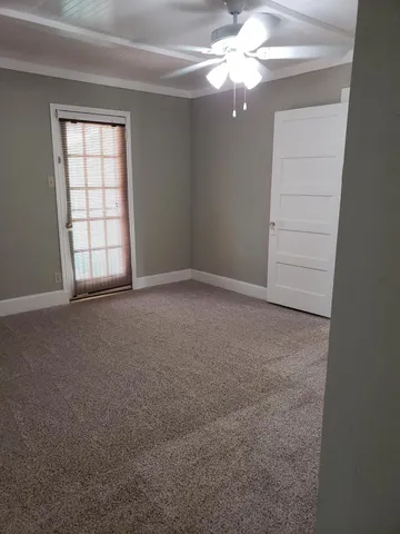 an empty room with windows and fan