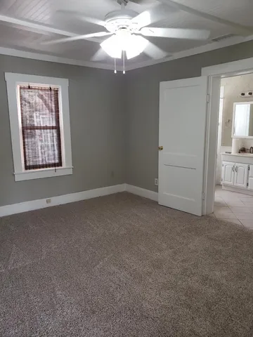 a view of a room with a ceiling fan and a window