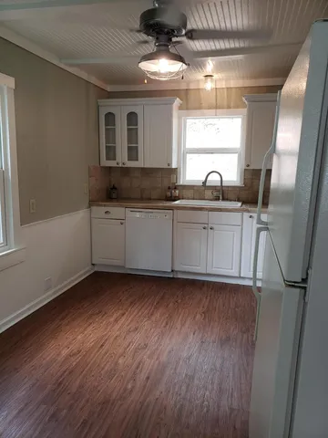 a kitchen with sink cabinets and wooden floor