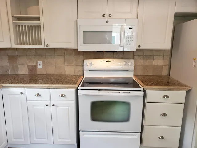 a stove top oven sitting inside of a kitchen