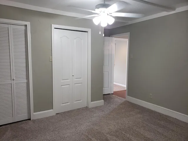 an empty room with a ceiling fan and a window