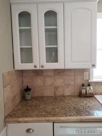 a kitchen with a granite countertop sink and cabinets