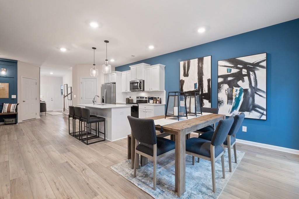 57 Scout Way Newnan, GA 30263 - Photo 15 of 37 a dining room with stainless steel appliances kitchen island granite countertop a table chairs and a oven