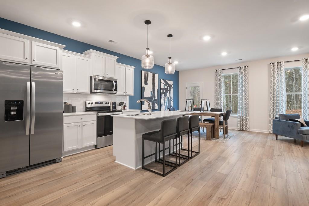 57 Scout Way Newnan, GA 30263 - Photo 6 of 37 a kitchen with kitchen island granite countertop a sink a counter top space stainless steel appliances and cabinets