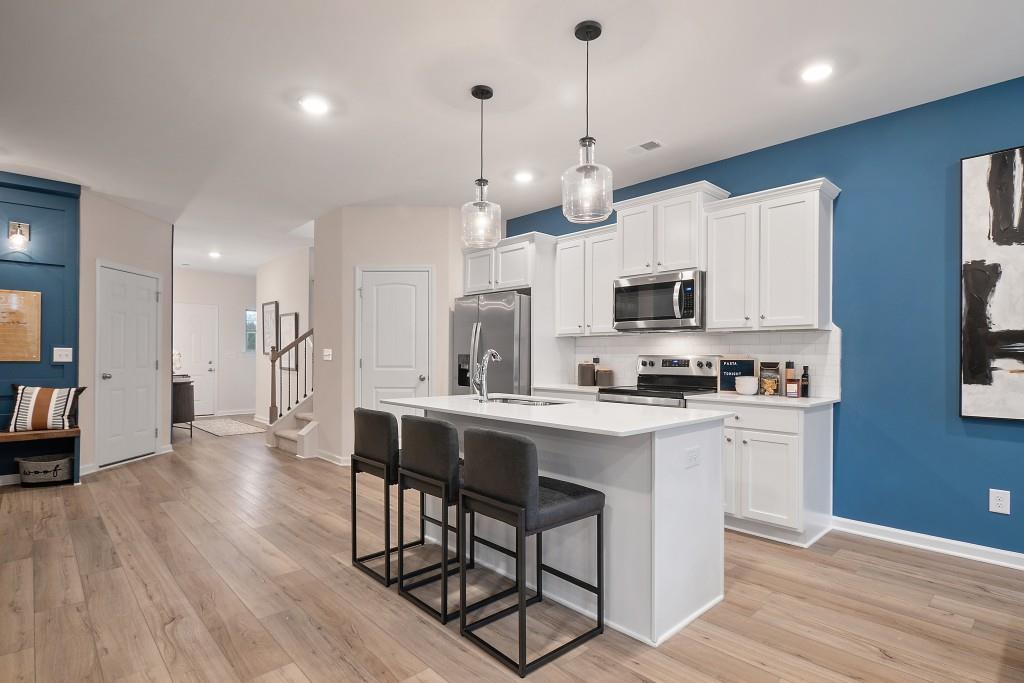 57 Scout Way Newnan, GA 30263 - Photo 8 of 37 a large kitchen with cabinets chairs and wooden floor