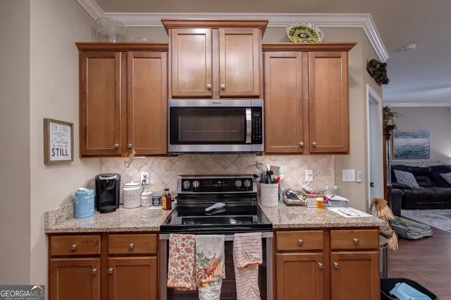 a kitchen with stainless steel appliances granite countertop a stove a sink and a microwave