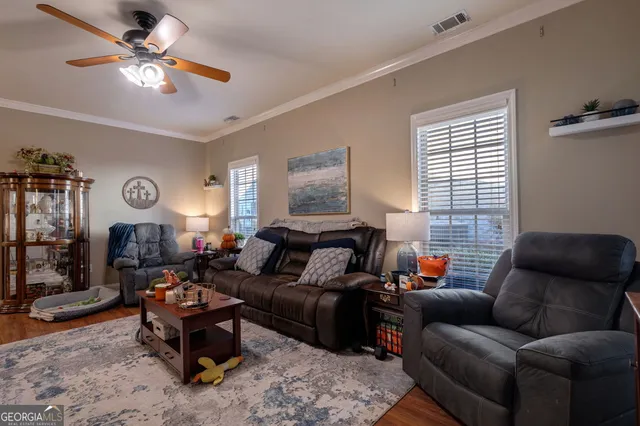 a living room with furniture ceiling fan and a window
