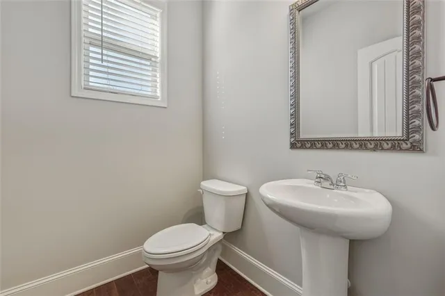 a bathroom with a sink toilet and a mirror