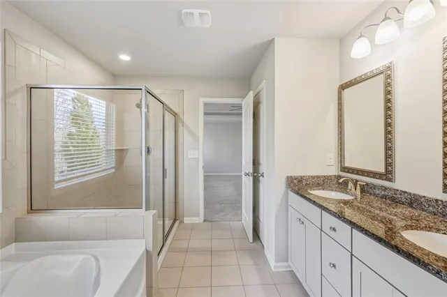 a spacious bathroom with a granite countertop tub sink and mirror