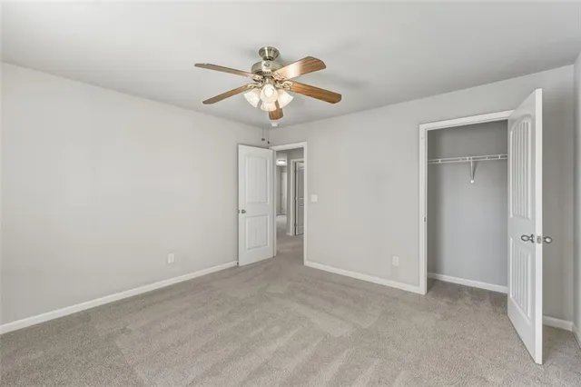 a view of an empty room and chandelier fan