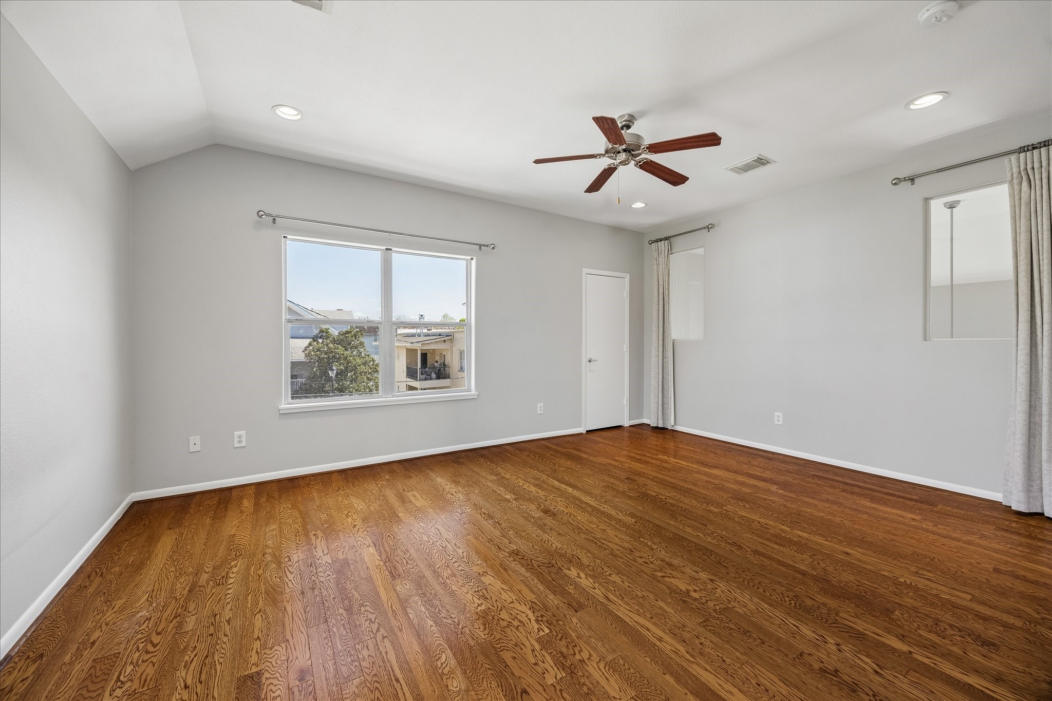 3022 Caroline Street Houston, TX 77004 - Photo 15 of 23 an empty room with wooden floor chandelier fan and windows