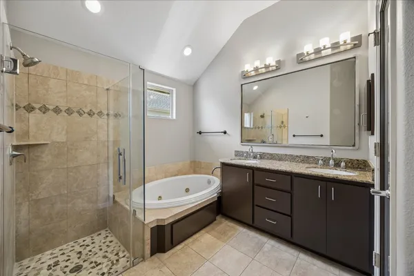 a bathroom with a granite countertop sink a large mirror and a bathtub