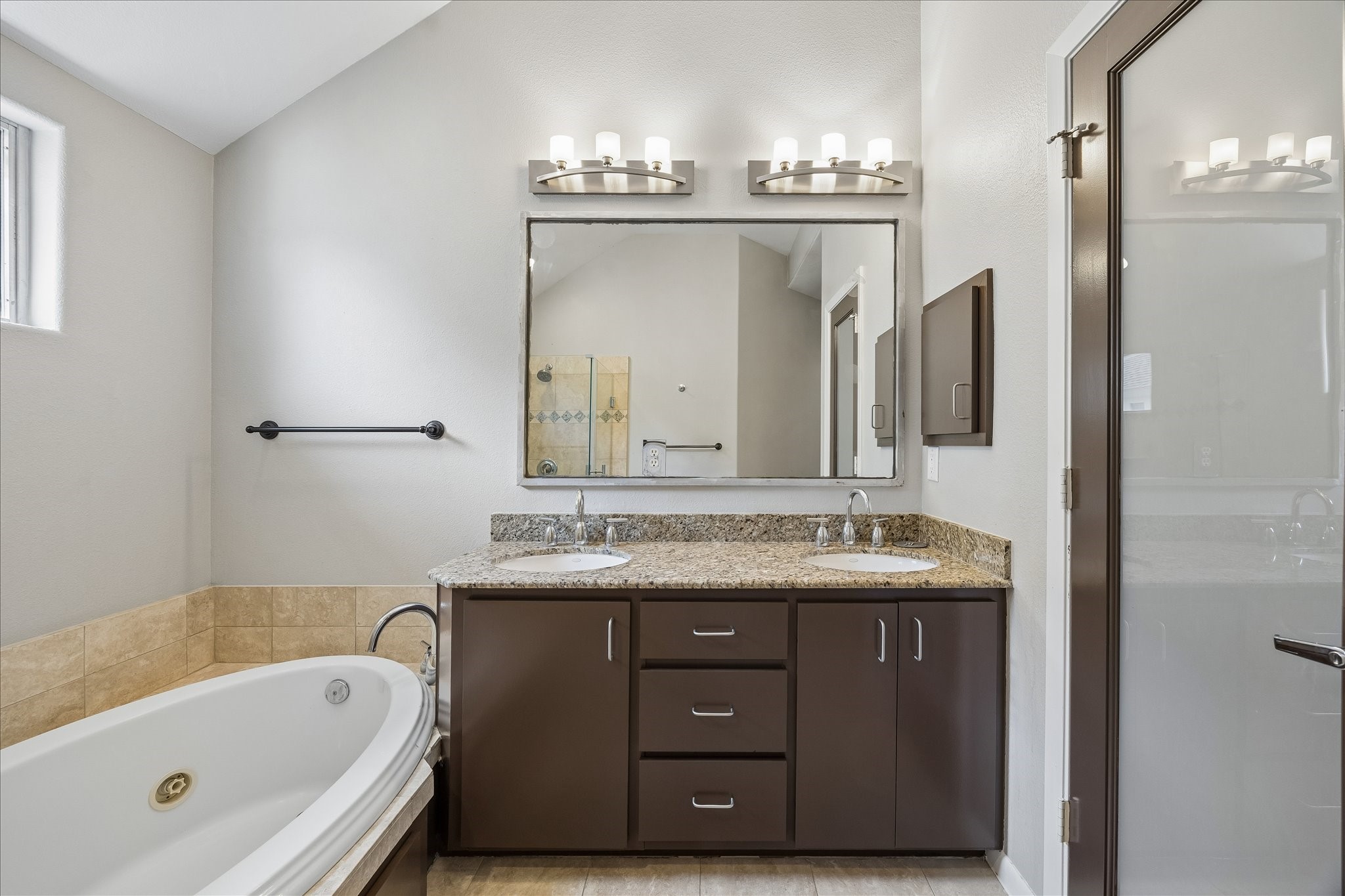 3022 Caroline Street Houston, TX 77004 - Photo 18 of 23 a bathroom with a granite countertop sink a large mirror and a bathtub