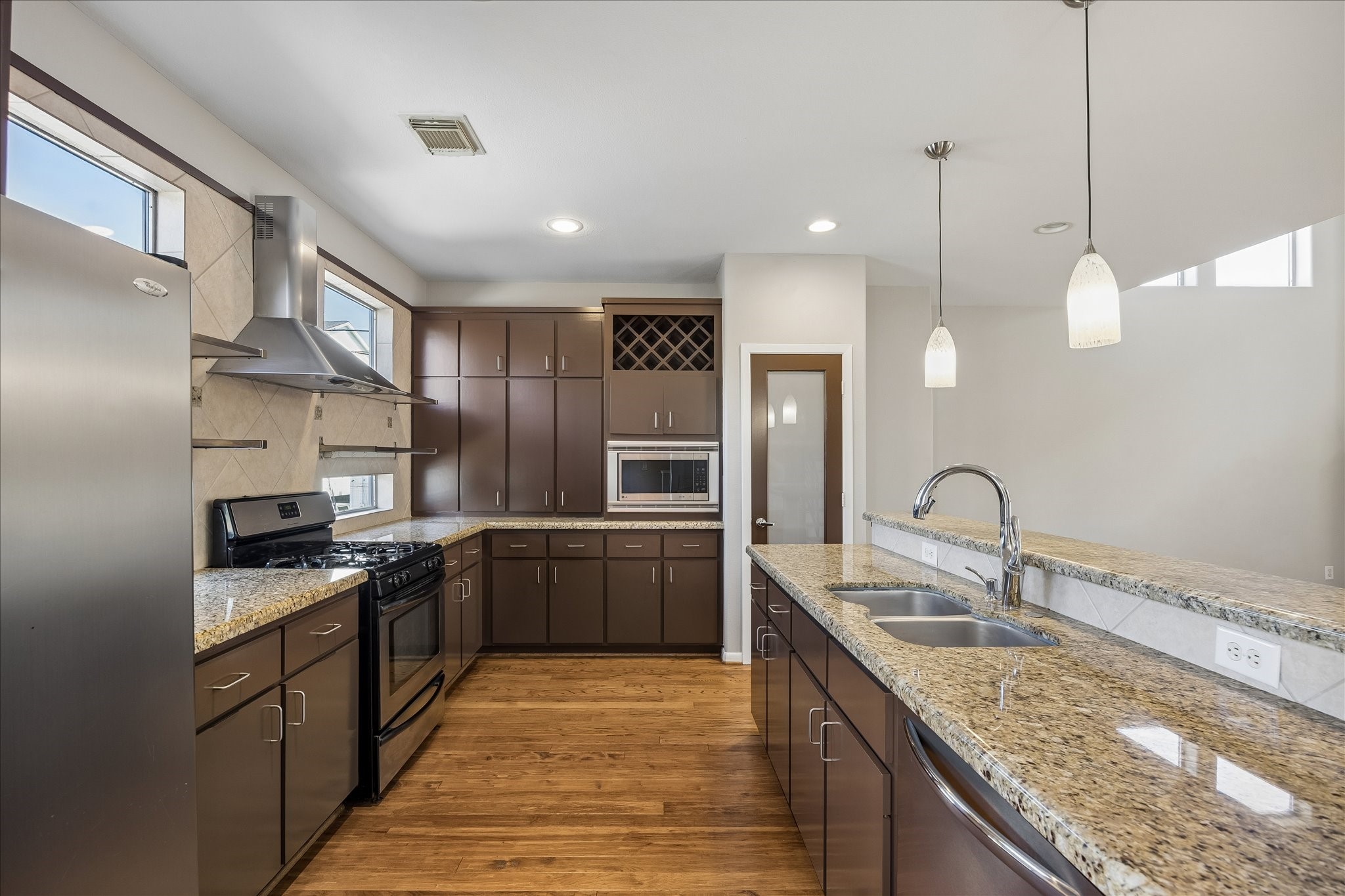 3022 Caroline Street Houston, TX 77004 - Photo 7 of 23 a kitchen with stainless steel appliances granite countertop a sink a stove and refrigerator