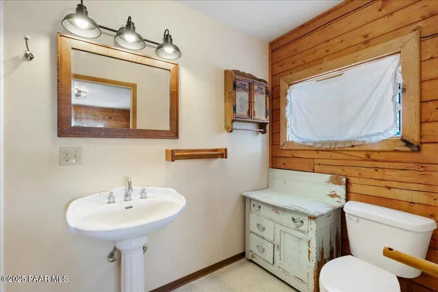 a bathroom with a toilet sink and mirror