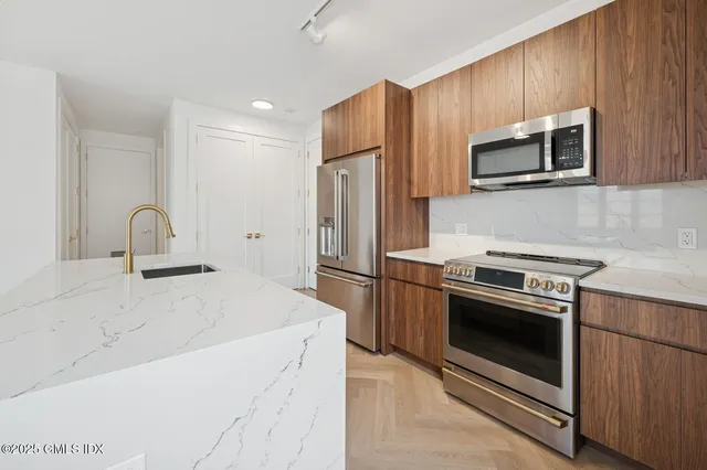 a kitchen with stainless steel appliances a stove microwave and sink