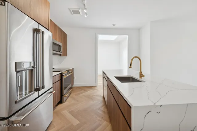 a kitchen with stainless steel appliances granite countertop a sink stove and refrigerator
