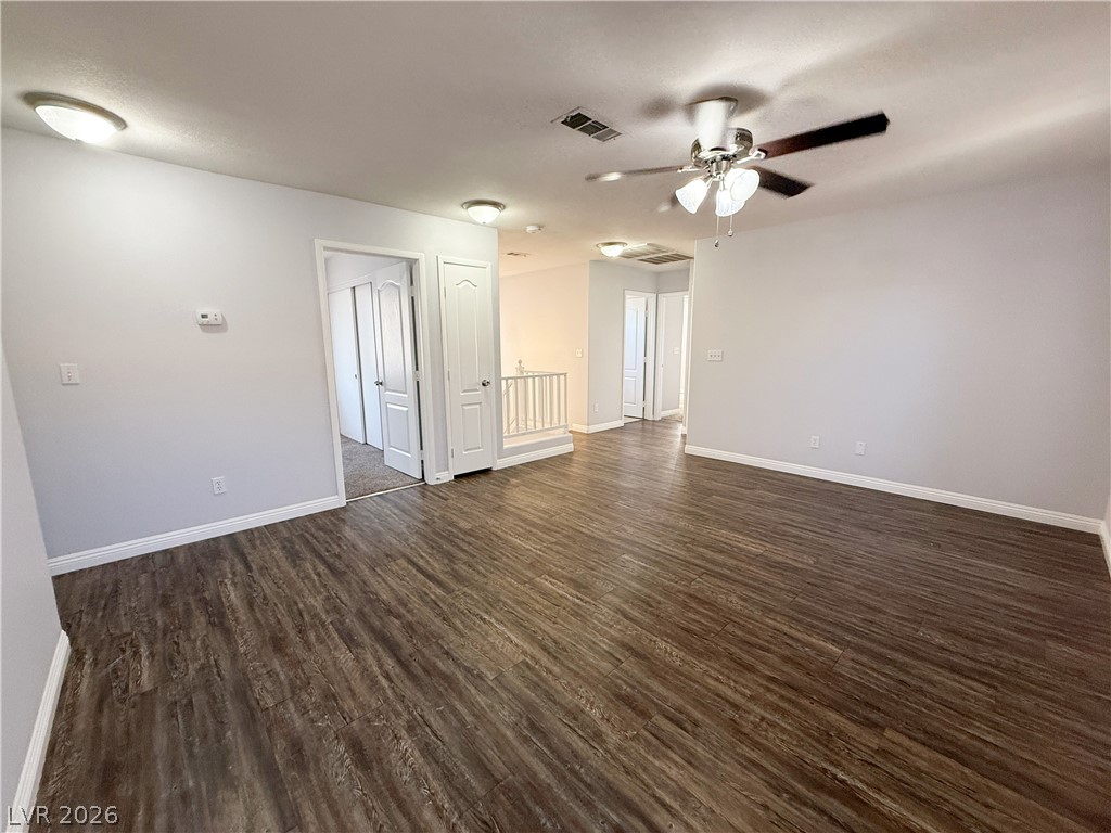 2185 Polynesia Circle Henderson, NV 89074 - Photo 24 of 37 The open-concept living area features rich wood flooring and a contemporary ceiling fan.