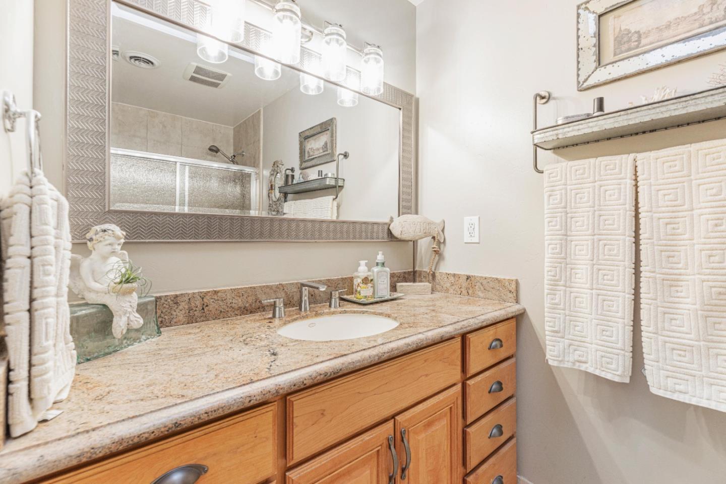 150 Jonquil Lane Hollister, CA 95023 - Photo 32 of 61 a bathroom with a granite countertop sink a mirror and shower