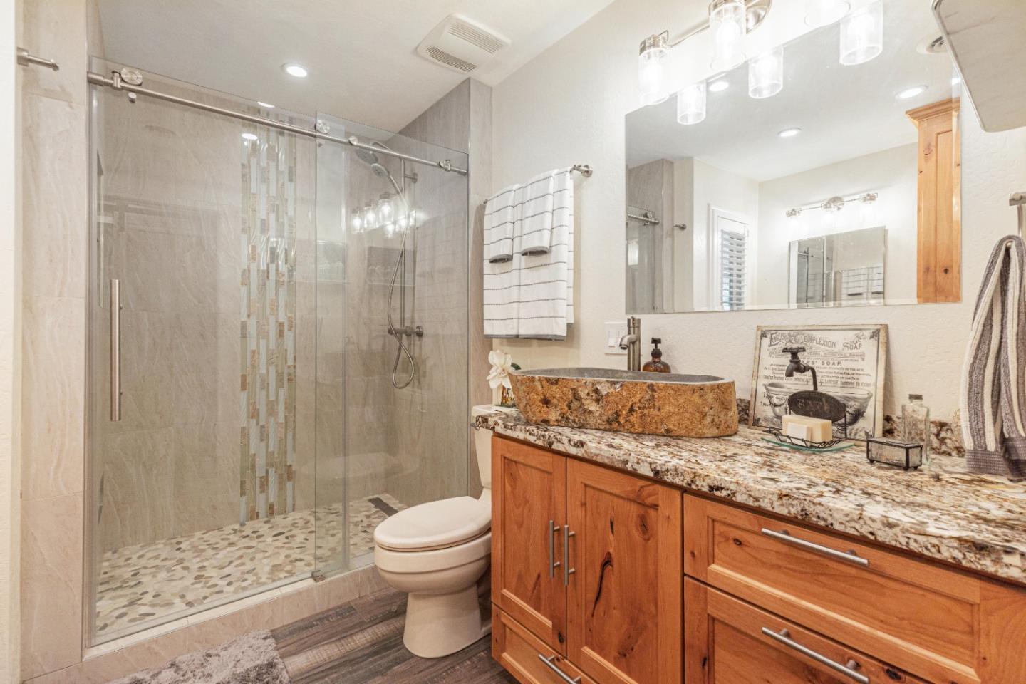 150 Jonquil Lane Hollister, CA 95023 - Photo 40 of 61 a bathroom with a granite countertop sink a toilet a mirror and shower
