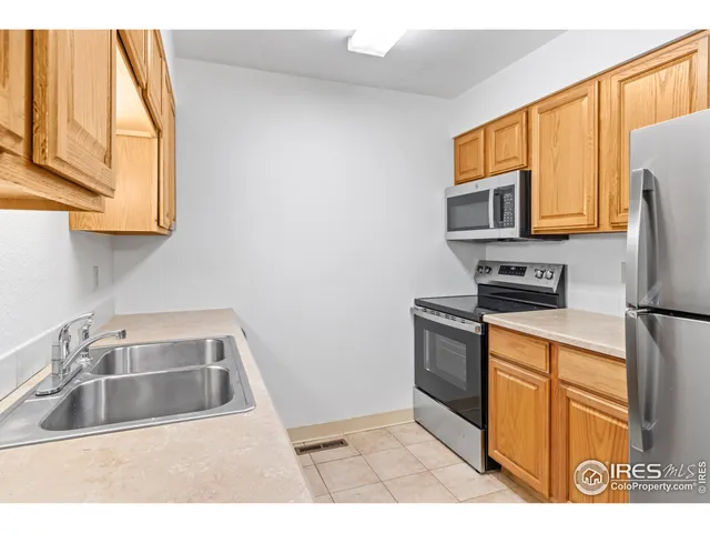a kitchen with a sink a stove top oven a refrigerator and cabinets