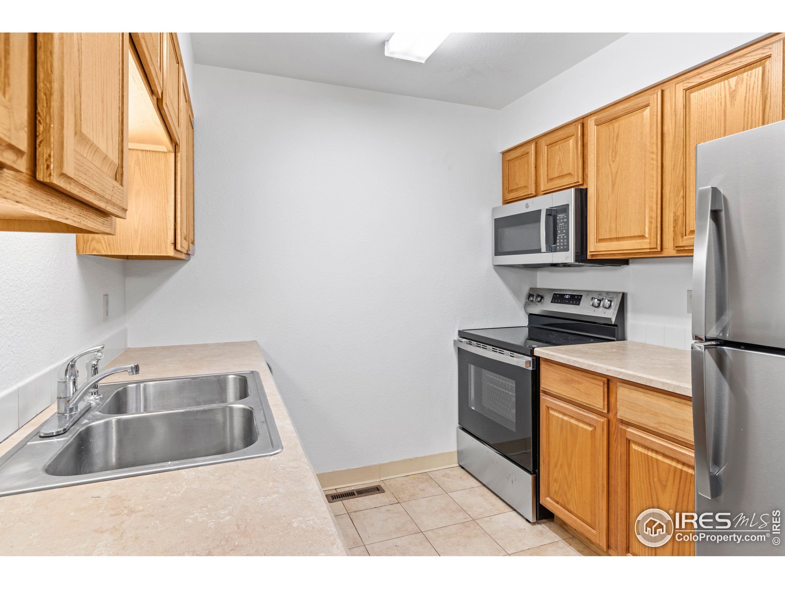 1155 South St Vrain Avenue, Unit 13 Estes Park, CO 80517 - Photo 7 of 18 a kitchen with a sink a stove top oven a refrigerator and cabinets