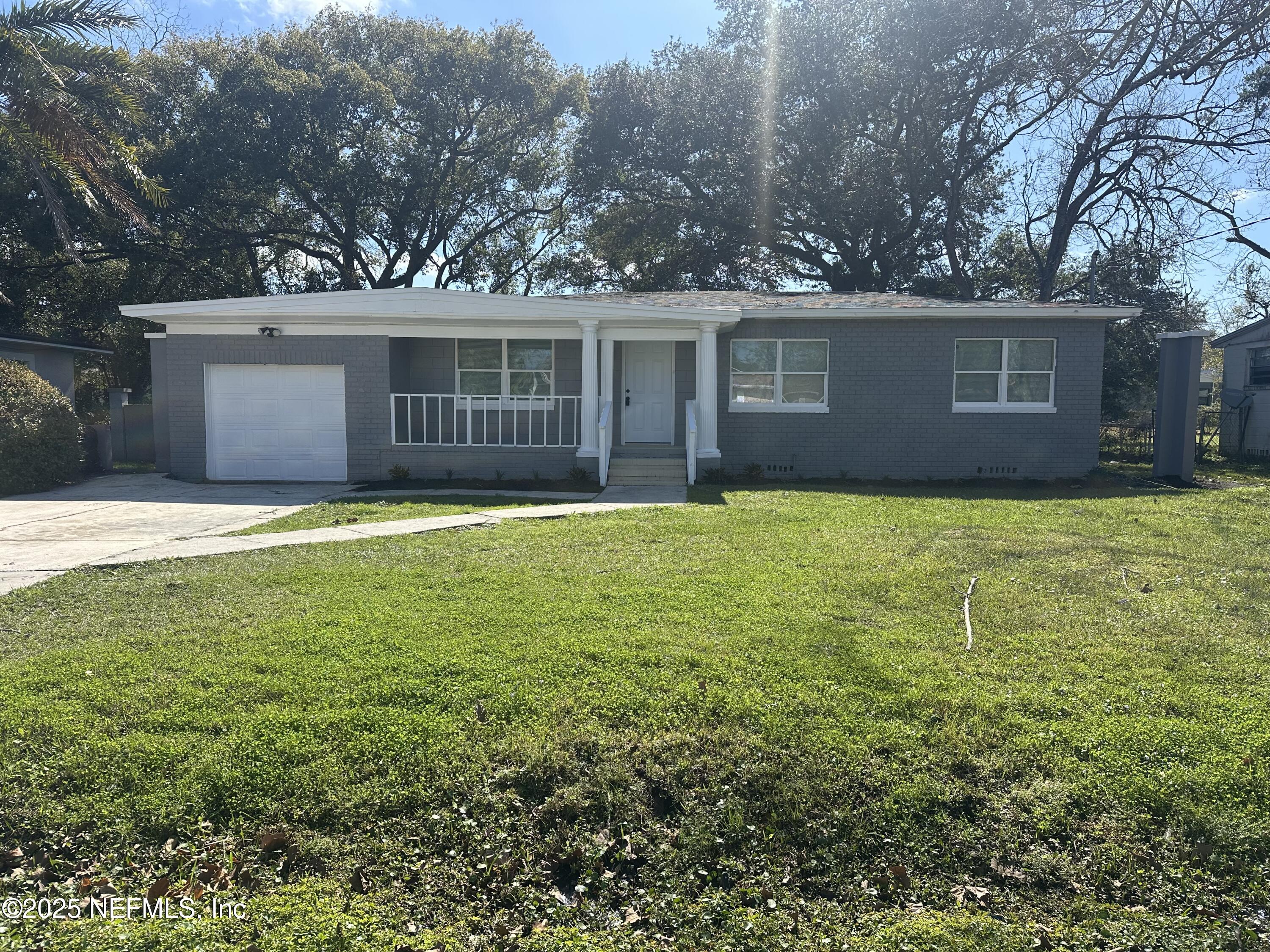 8049 Ramsgate Road Jacksonville, FL 32208 - Photo 2 of 14 a view of a yard in front of a house with large tree