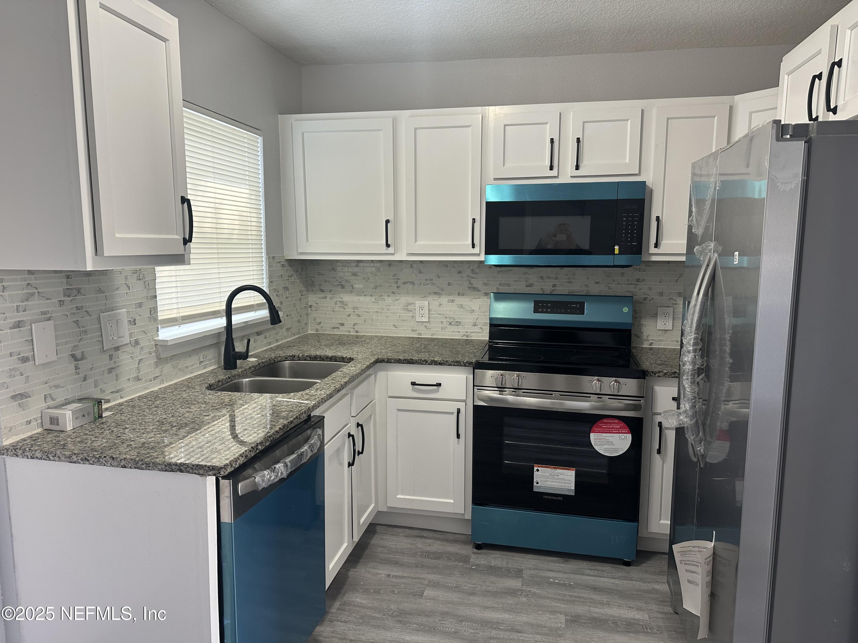 8049 Ramsgate Road Jacksonville, FL 32208 - Photo 5 of 14 a kitchen with a sink stove and refrigerator