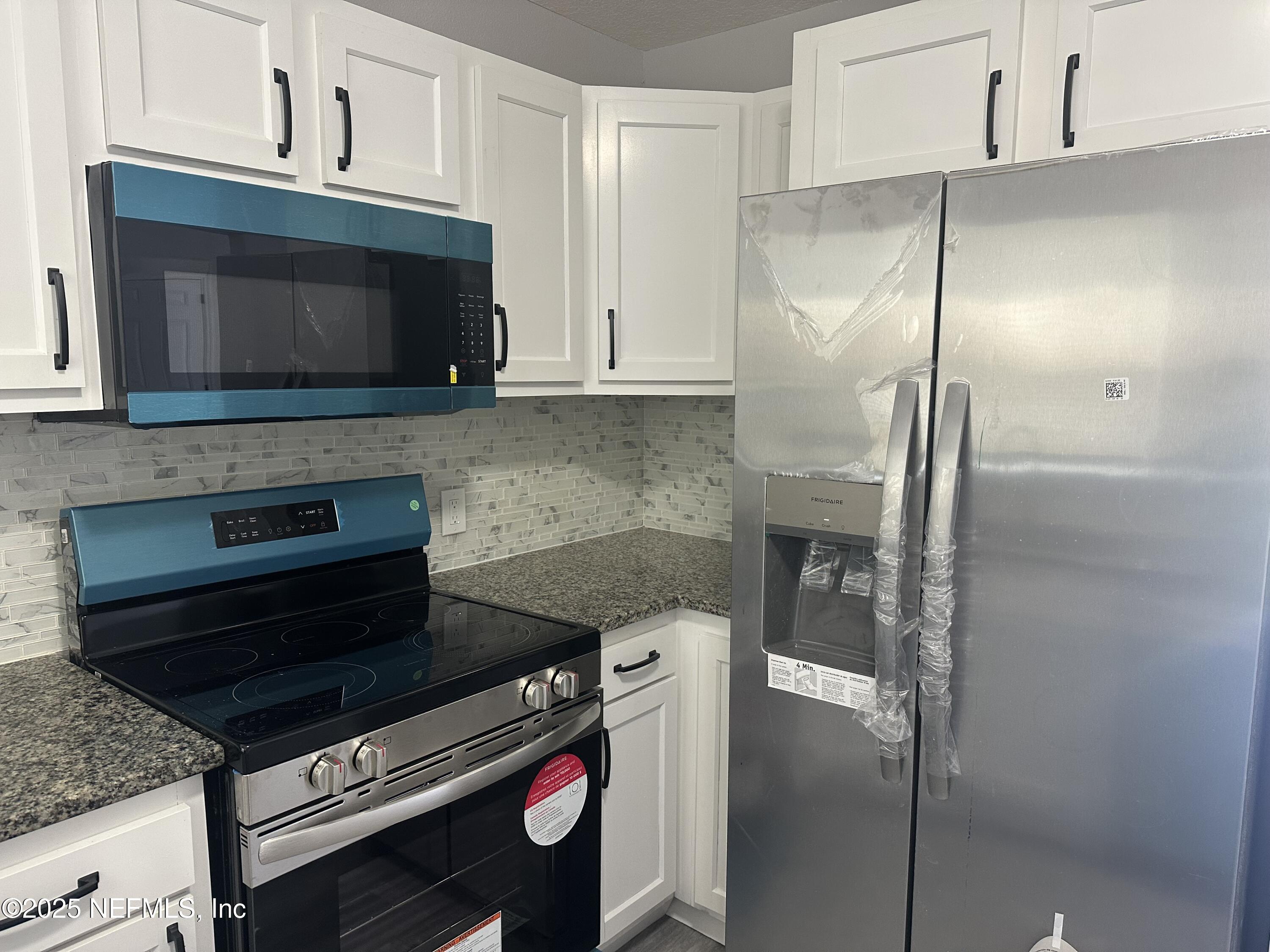 8049 Ramsgate Road Jacksonville, FL 32208 - Photo 6 of 14 a kitchen with a stove and a microwave