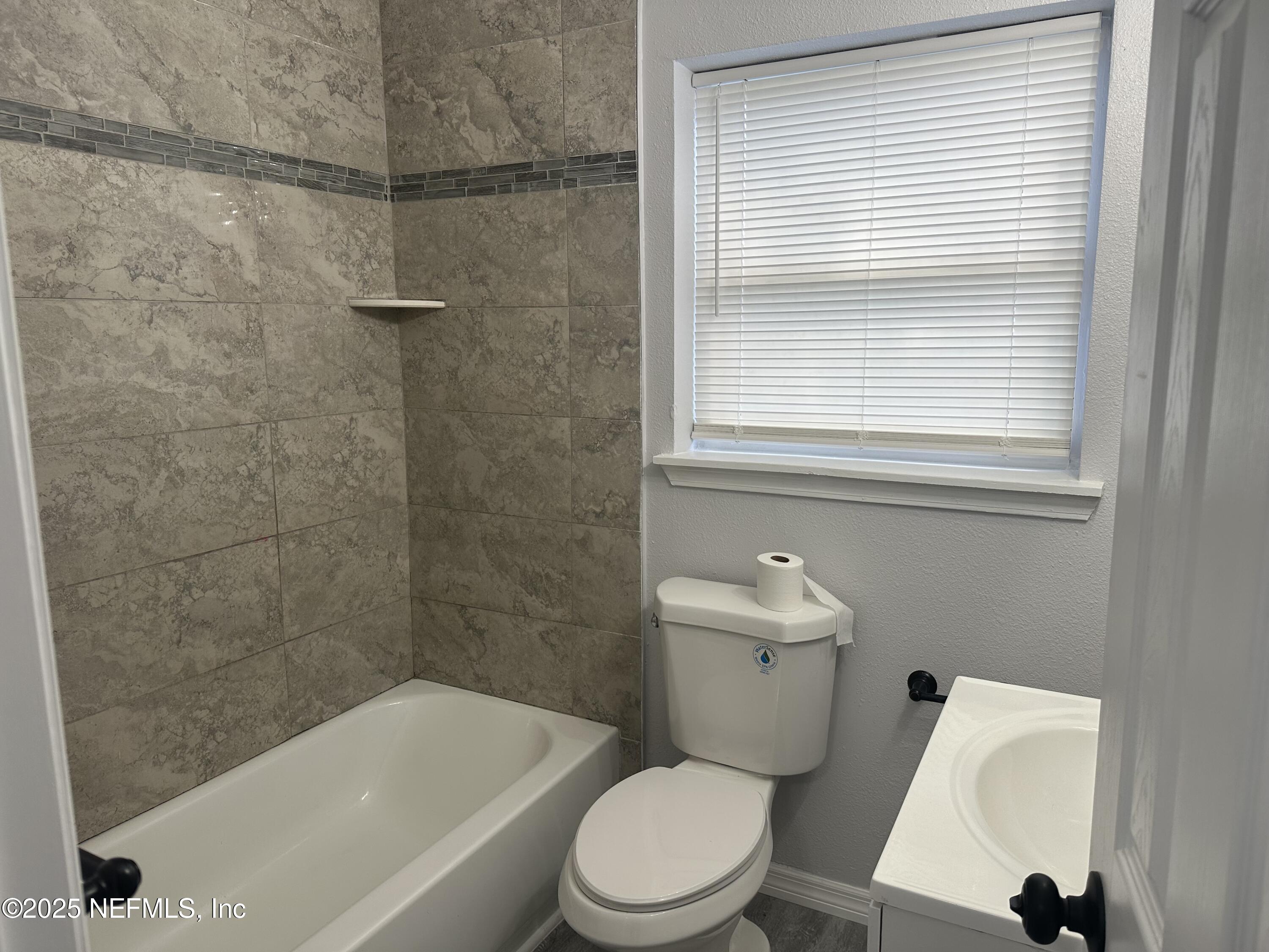8049 Ramsgate Road Jacksonville, FL 32208 - Photo 10 of 14 a white toilet sitting next to a bath tub