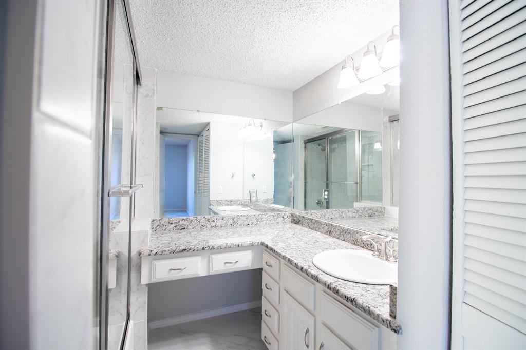 4777 Cedar Springs Road, Unit 4D Dallas, TX 75219 - Photo 11 of 20 a bathroom with a granite countertop sink and a mirror