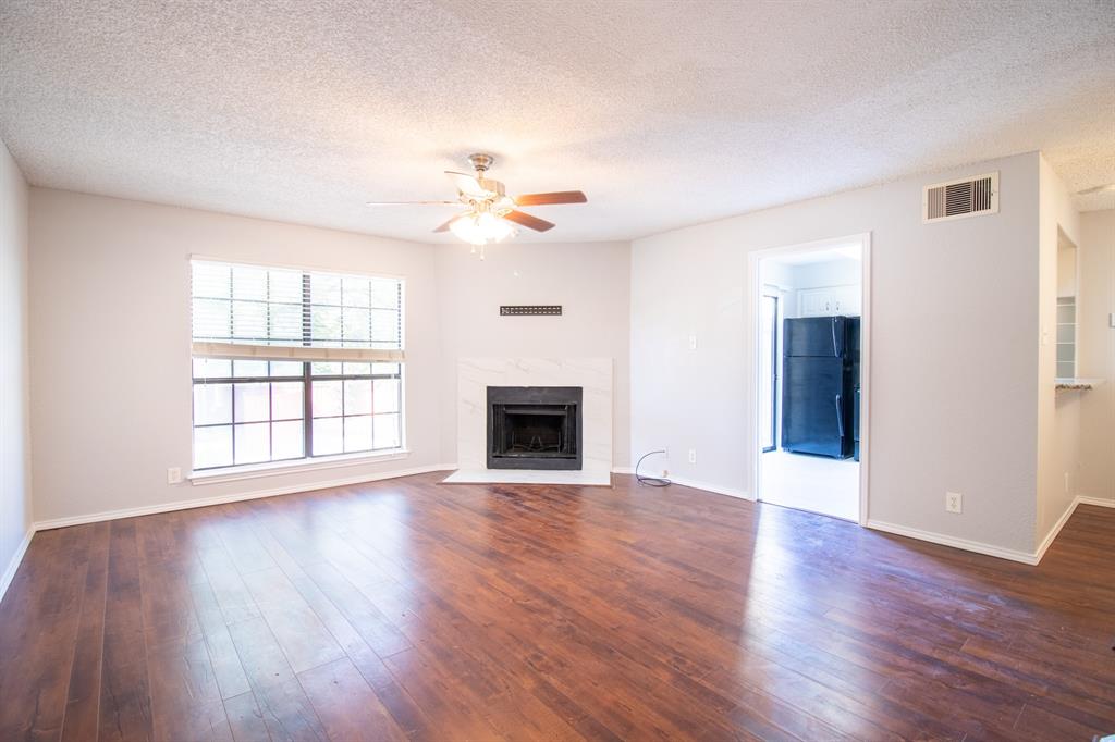 4777 Cedar Springs Road, Unit 4D Dallas, TX 75219 - Photo 4 of 20 an empty room with wooden floor fireplace and windows