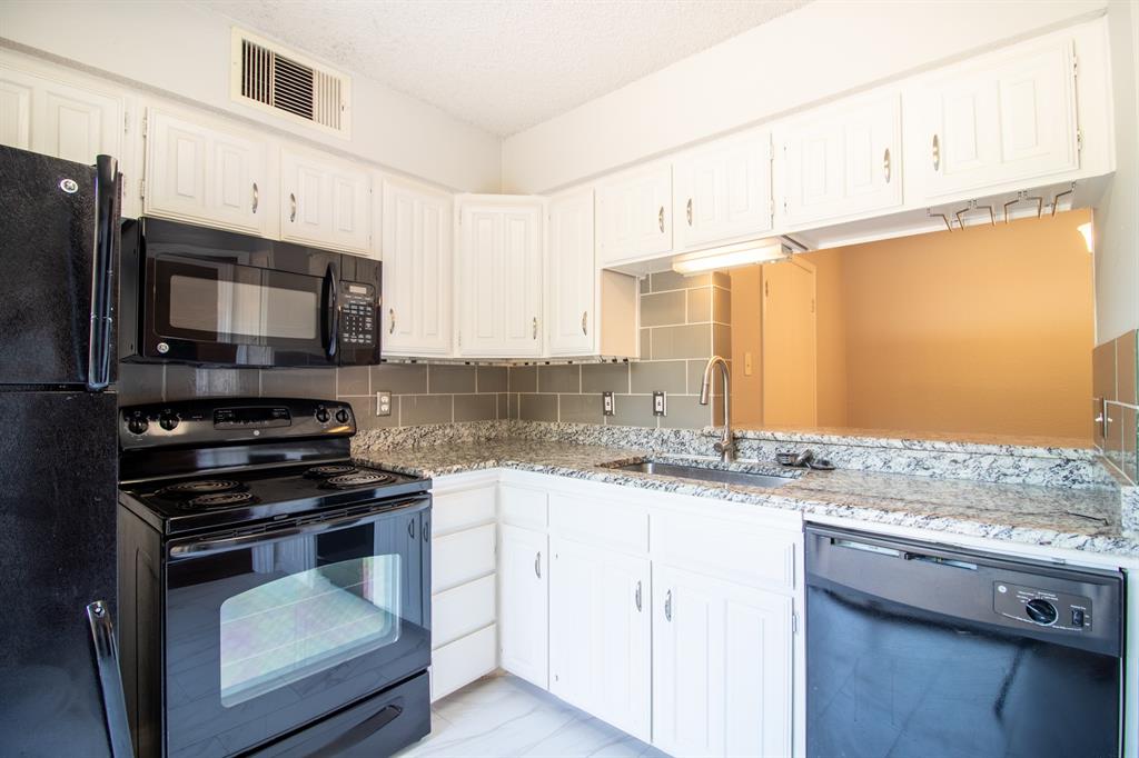 4777 Cedar Springs Road, Unit 4D Dallas, TX 75219 - Photo 6 of 20 a kitchen with granite countertop a sink stainless steel appliances and cabinets