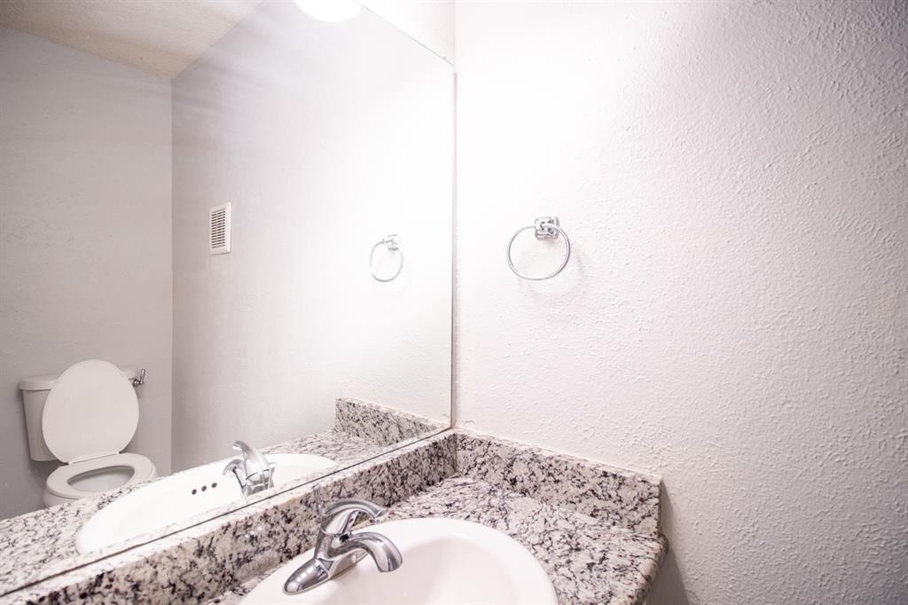 4777 Cedar Springs Road, Unit 4D Dallas, TX 75219 - Photo 9 of 20 a bathroom with a granite countertop sink and a mirror
