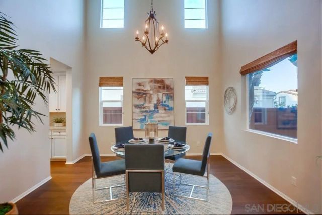 a view of a dining room with furniture a chandelier and wooden floor