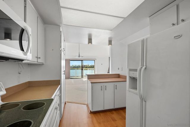 a kitchen with stainless steel appliances granite countertop a sink and a refrigerator