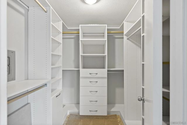 a view of walk in closet with empty racks