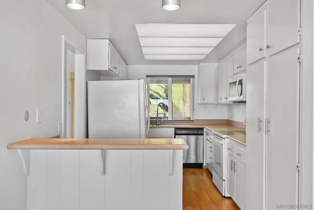 a kitchen with stainless steel appliances a white cabinets and a window