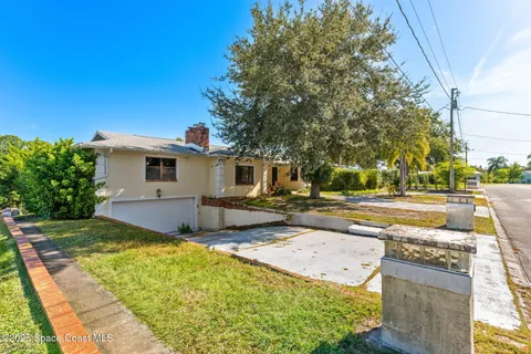 a view of a house with backyard and trees