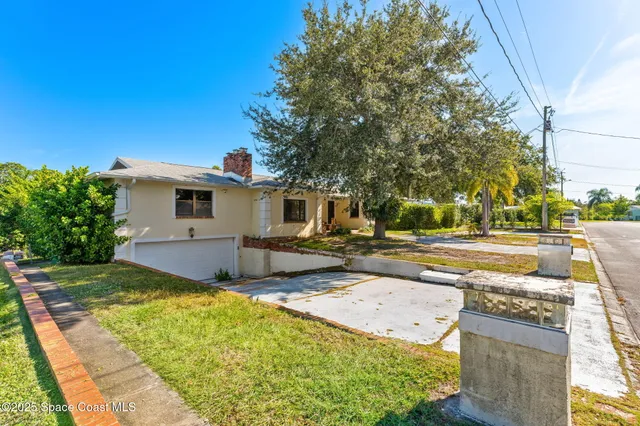 a view of a house with backyard and trees