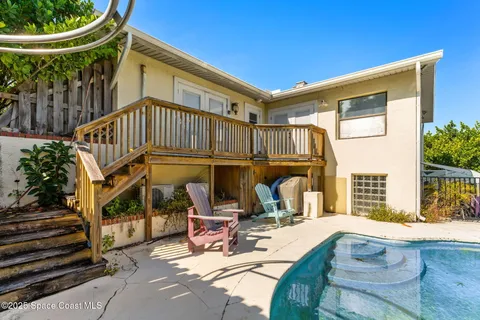 a view of a swimming pool with a patio and a yard