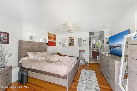 a bedroom with furniture a flat screen tv and a window