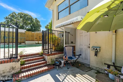 a view of a swimming pool with a patio and a yard