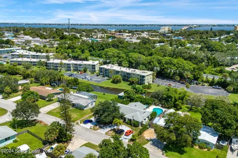 an aerial view of a residential houses with outdoor space and lake view
