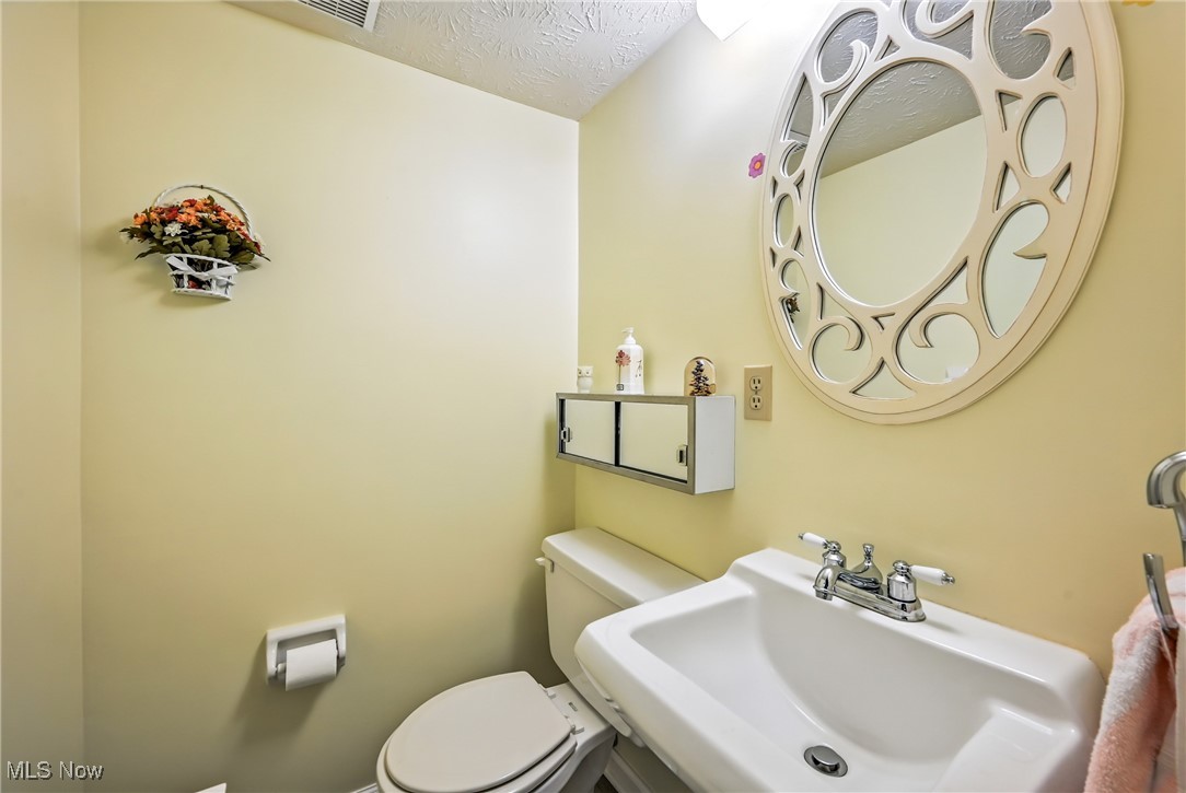 7797 Raglan Drive Northeast Warren, OH 44484 - Photo 46 of 50 Half bathroom featuring a sink and a textured ceiling