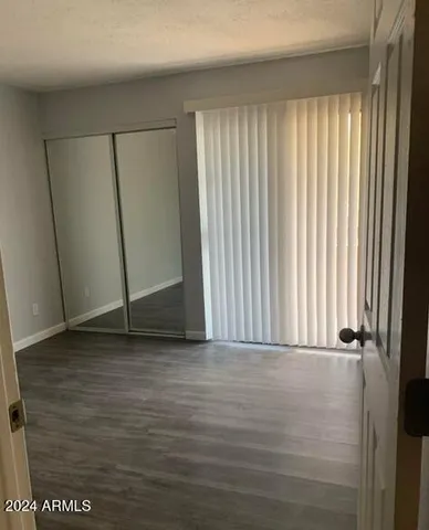 a view of a room with wooden floor and a window