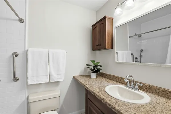 a bathroom with a granite countertop sink and a mirror