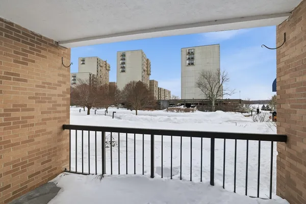 a view of a balcony and a couple of cars parked in parking lot